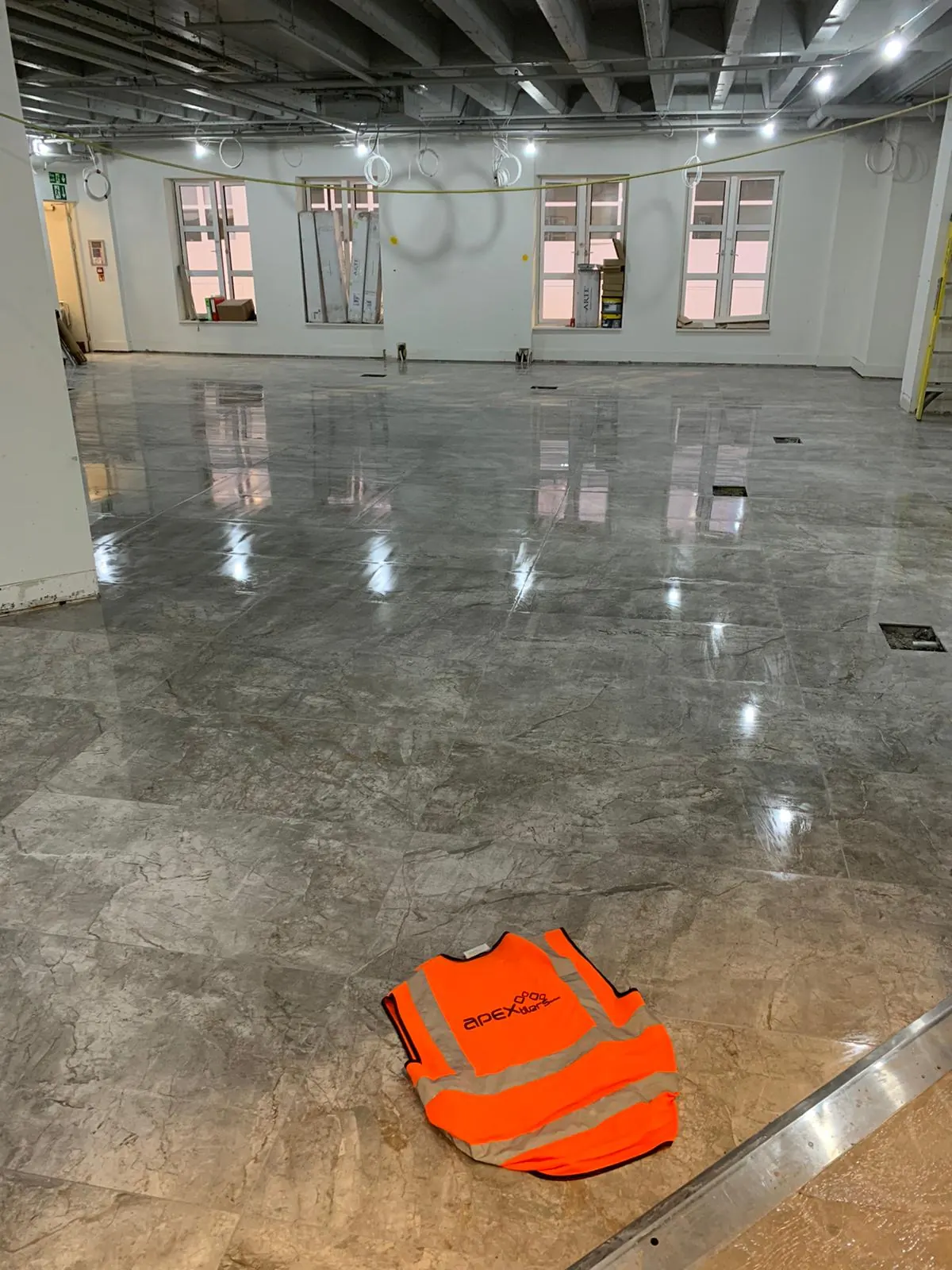 Large-format grey porcelain floor tiles laid in a commercial office space